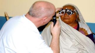 Man testing woman's eyes for glasses