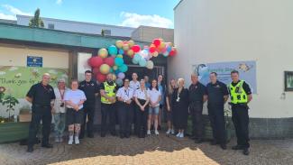 Group of prison staff and partnership organisations standing outside the prison visitors centre