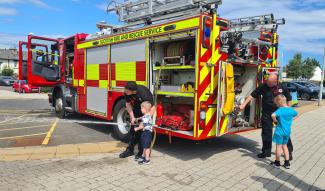 Two children being shown around a fire engine