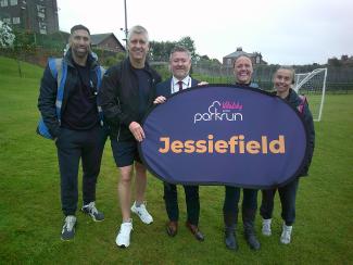 Group of staff holding Jessiefield parkrun sign