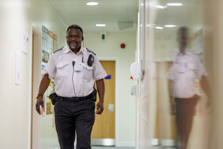 SPS Prison Officer walking down corridor. 